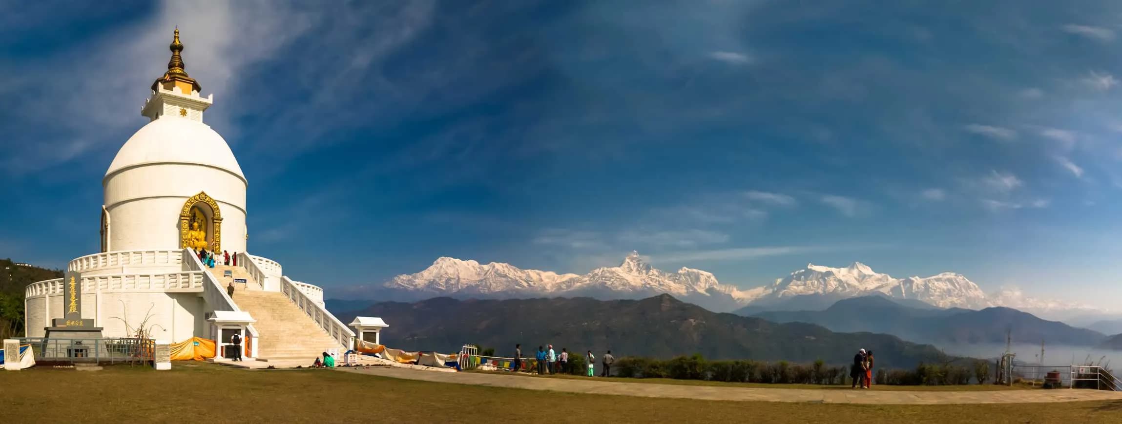 World Peace Pagoda on a hill with a panoramic view of the snow-capped Annapurna mountains